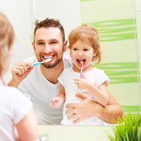 Papa und Tochter putzen sich die Zähne